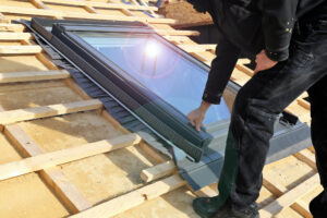man installing skylight window
