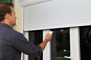 man controlling white electric blinds